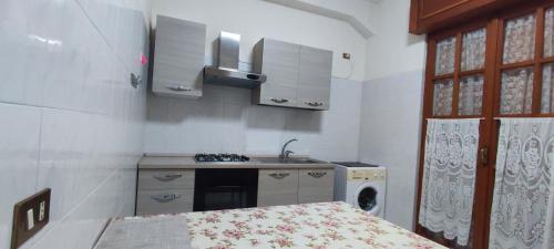 een kleine keuken met een wastafel en een fornuis bij Napoli Pompei Sorrento Appartamento con Posto Auto in Gragnano