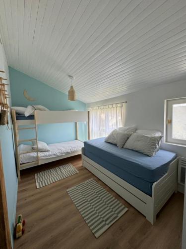 a bedroom with a bed and bunk beds in it at Le Lodge de l'océan - Maison familiale en bois neuve - Piscine chauffée in Biscarrosse