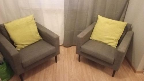 two chairs with yellow pillows in a room at UrbannestApartments/Lip2/7 in Katowice
