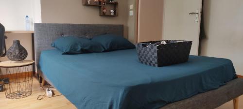 - un lit avec des draps bleus et un panier dans l'établissement Location chambre au calme proche circuit des 24 heures, à Mulsanne