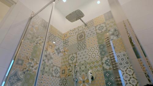 een badkamer met een douche en mozaïektegels aan de muur bij Villa Zefiro Suites e Events in Battipaglia