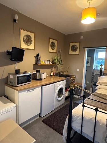 a room with a kitchen with a microwave and a bed at The Stable Room at The Grange in Lincolnshire