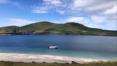 a boat in a large body of water with a mountain at Seaview House Reenard South in Cahersiveen