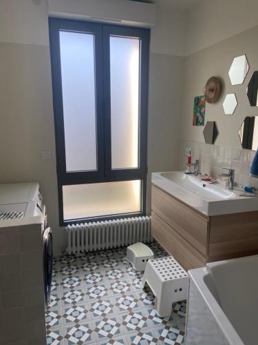 La salle de bains est pourvue d'un lavabo et d'une fenêtre. dans l'établissement Cosy house in Versailles - Paris 2024, à Versailles