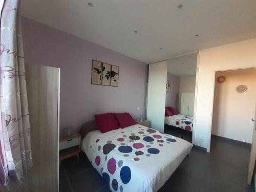 - une chambre dotée d'un grand lit avec une couverture en point de polka dans l'établissement Proche Gare et Centre Ville, à Narbonne