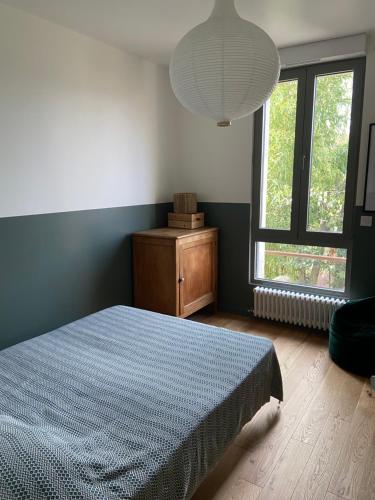 een slaapkamer met een bed en een groot raam bij Cosy house in Versailles - Paris 2024 in Versailles