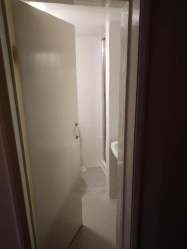 una puerta abierta a un baño con aseo en The monk hotel en Towcester