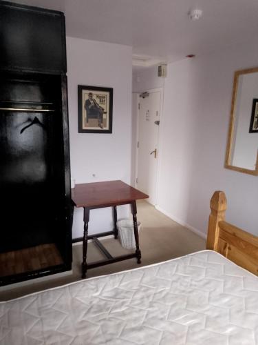 a bedroom with a bed and a table in a room at The monk hotel in Towcester