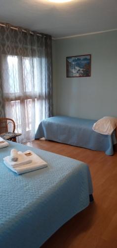 um quarto com 2 camas e uma janela em L'Albore em Costigliole Saluzzo