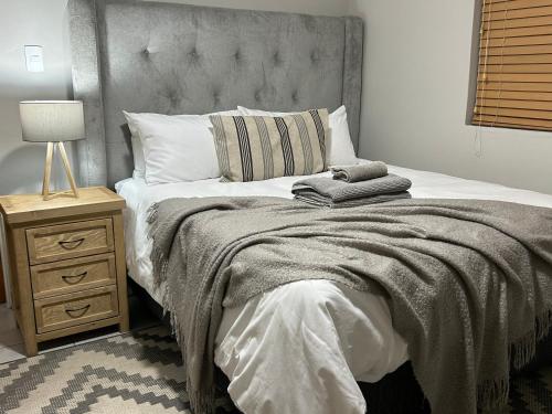 a bedroom with a large bed and a night stand at Hansen@15 Self Catering Studio in Piet Retief