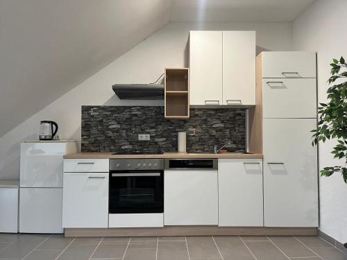 cocina con armarios blancos y fogones en Simplex Apartments Am Europaplatz en Karlsruhe