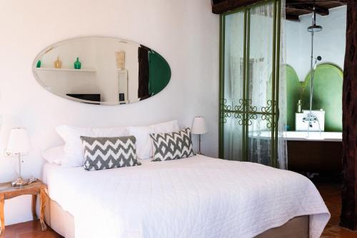 a bedroom with a white bed and a mirror at ES CUCONS RURAL HOTEL in San Antonio