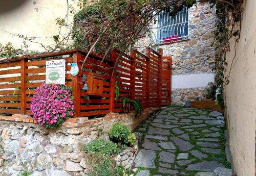 a wooden fence with flowers on a stone wall at La Borgata in Tovo San Giacomo