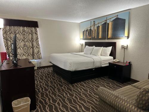 a hotel room with a bed and a couch at Days Inn & Suites by Wyndham Casey in Casey