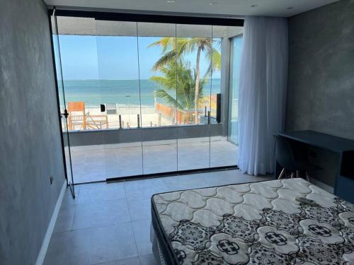 a bedroom with a bed and a view of the beach at Casa de praia Itamaracá - Pontal da Ilha in Itamaracá