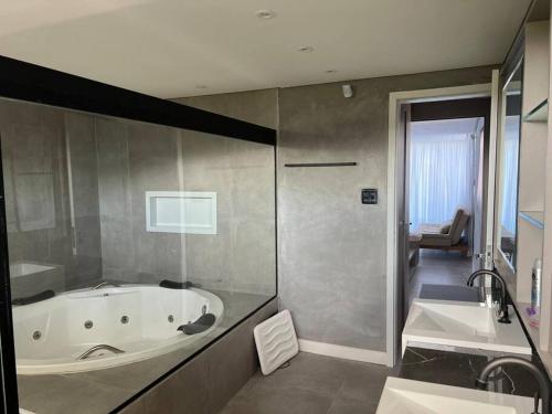 a bathroom with a tub and a shower and a sink at Casa de praia Itamaracá - Pontal da Ilha in Itamaracá