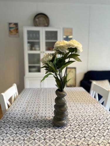a vase with white flowers sitting on a table at Villa ROMA in Soustons