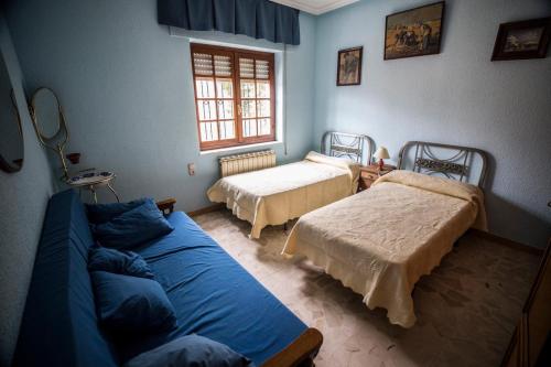 uma sala de estar com duas camas e um sofá em CASA EL CARMEN 1 em Ciudad-Rodrigo