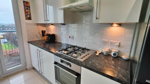 a kitchen with a stove top oven next to a window at La Casita, Your Home Away from Home - Free Parking in Glasgow