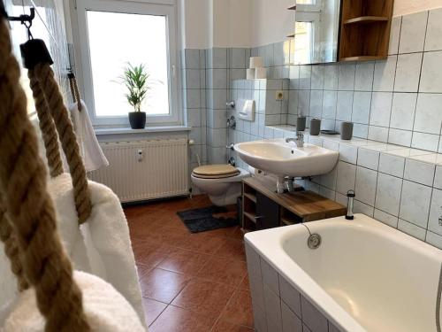 a bathroom with a tub and a sink and a toilet at Moderne Wohnung nahe Bahnhof und dem Goitzschesee in Bitterfeld