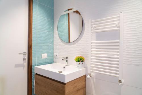 Un baño con un lavabo blanco y un espejo. en Monteleone Apartment, en Palermo