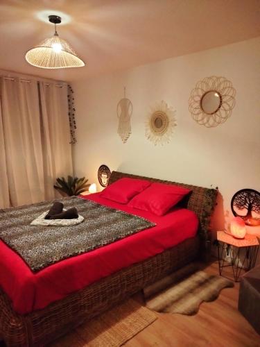 une chambre avec un grand lit avec des oreillers rouges dans l'établissement Maison Prestige Le Donjon des Plaisirs Jacuzzi, à Montluel