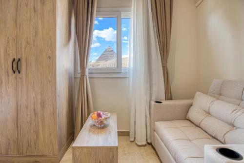 a living room with a couch and a window at Soul Pyramids View in Cairo