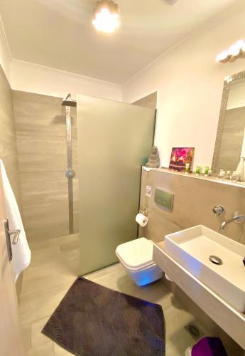 a bathroom with a toilet and a sink at T H E BERLIN Studios and Suites in Nea Vrasna