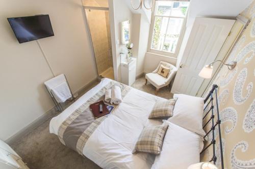 a bedroom with a large white bed with pillows at 2 Cambridge Villas B & B in Ambleside