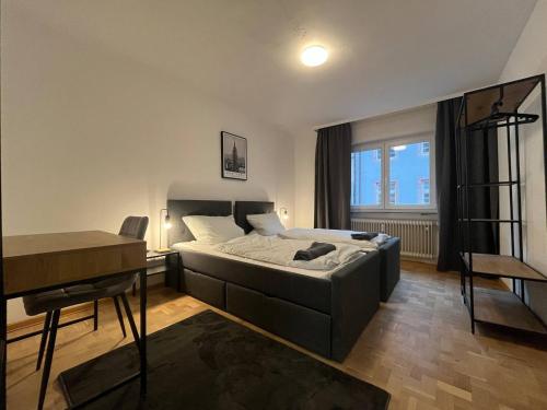 Schlafzimmer mit einem Bett, einem Schreibtisch und einem Tisch in der Unterkunft Simplex Apartments Am Schwabentor in Freiburg im Breisgau
