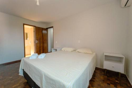 um quarto com uma grande cama branca e 2 almofadas em Apartamento 3 Quartos Central com Ar SQ41 em Maringá