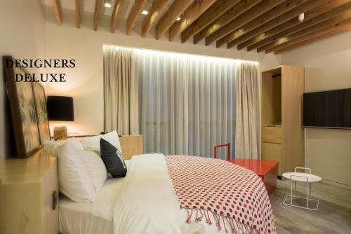 a bedroom with a white bed and a television at Hotel The Designers Dongdaemun in Seoul