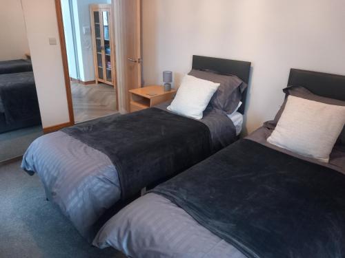 two beds sitting in a room with a mirror at Remarkable 2-Bed Apartment near Bognor beaches in Bognor Regis