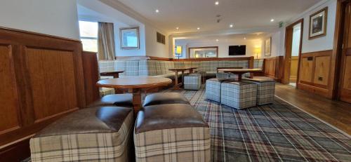 uma sala de estar com uma mesa e algumas cadeiras em Loch Long Hotel em Arrochar