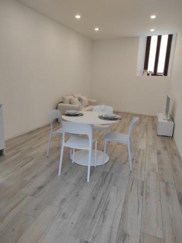 une salle à manger avec une table et des chaises blanches dans l'établissement Appartamento Via Varesella, à Brezzo
