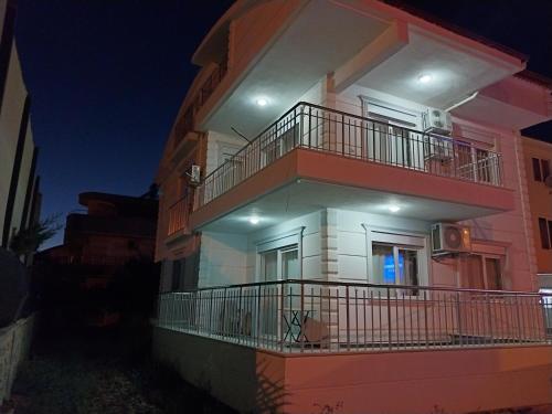 a apartment building with a balcony and a night at VİLLA BELİNAY in Belek