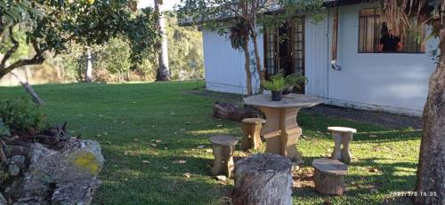 uma mesa e bancos no quintal de uma casa em Casa Gralha Azul em Lages