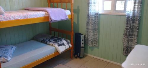 a bedroom with two bunk beds and a window at Casa Gralha Azul in Lages