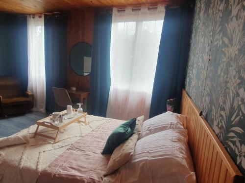 Un dormitorio con una cama con paredes azules y una mesa. en La Rosée - Studio Cosy à 50m des Thermes - Vue jardin, Wifi, Netflix, Smart TV, en Bourbonne-les-Bains