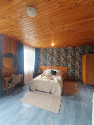 1 dormitorio con cama y techo de madera en La Rosée - Studio Cosy à 50m des Thermes - Vue jardin, Wifi, Netflix, Smart TV, en Bourbonne-les-Bains