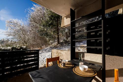 a dining table with a view of a snow covered yard at La belle Agathe, Vercors in Le Guâ
