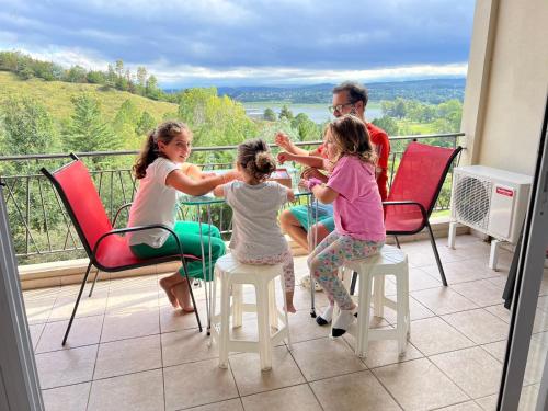 a group of three girls sitting at a table on a balcony at Condominio Monte Molinos - Departamento en Náutico frente al Lago in Villa Ciudad de América