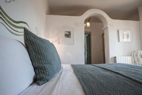 a bedroom with a bed with green and white pillows at ES CUCONS RURAL HOTEL in San Antonio