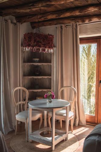 a table and chairs in a room with a window at ES CUCONS RURAL HOTEL in San Antonio