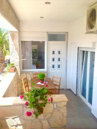 a porch of a house with a table and chairs at T H E BERLIN Studios and Suites in Nea Vrasna