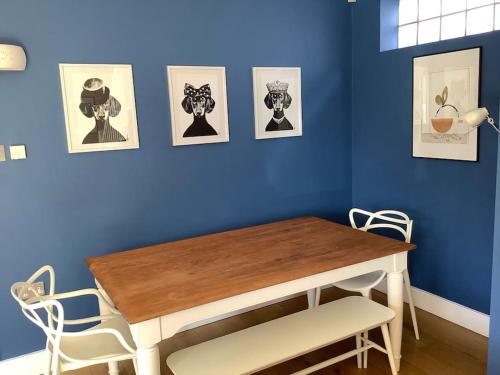 a dining room with a table and a blue wall at Time House Cottage in Huby