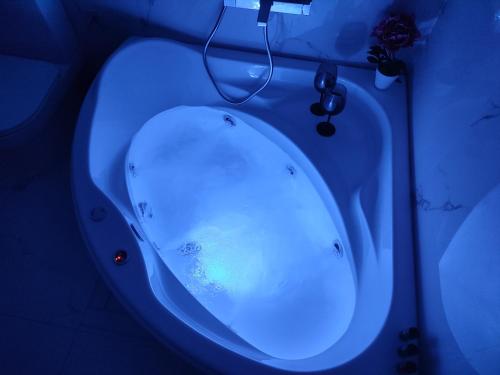a bath tub with a blue light in a bathroom at Amazing Apartments @ Monastiraki Subway Station in Athens
