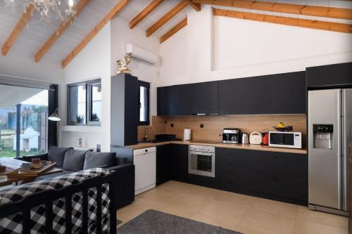 a kitchen with black and white appliances and a living room at Owl's Nest in Volos