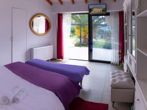 1 dormitorio con 2 camas, espejo y ventana en Owl's Nest, en Volos