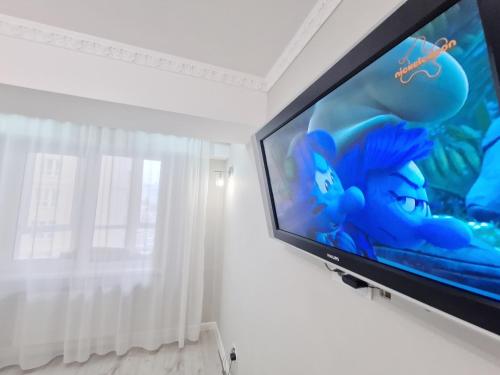 a flat screen tv in a room with a window at Gio Apartment in Chişinău